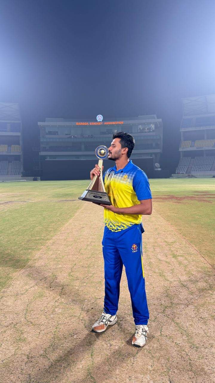 Koushik Vasuki holding the Vijay Hazare Trophy 2025